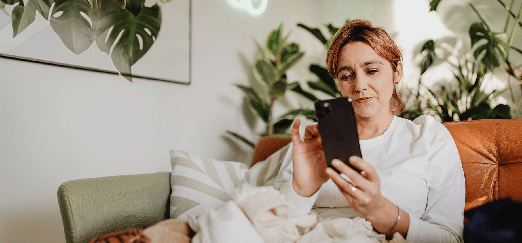 Woman relaxing on a sofa while using her phone
